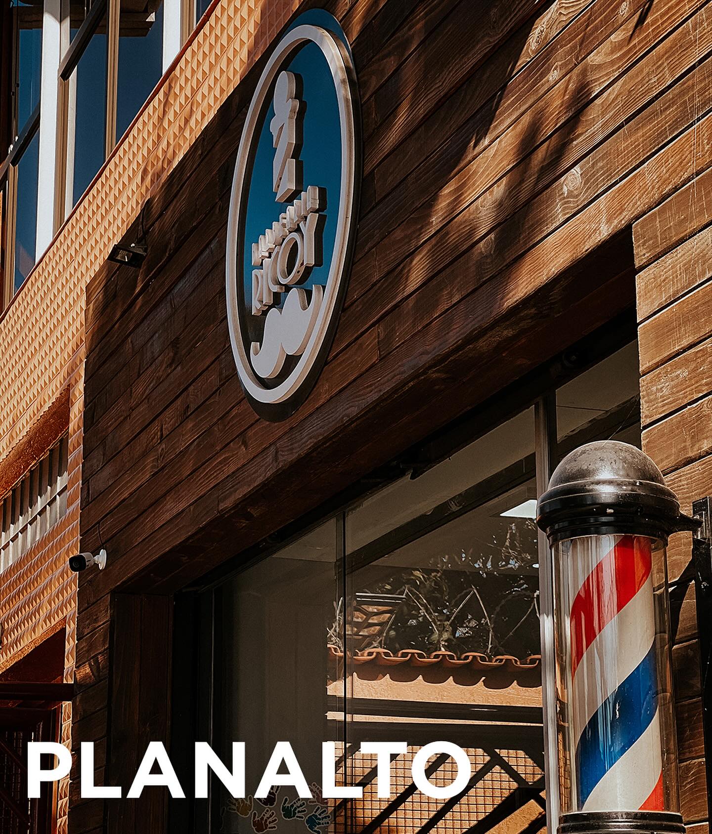Fachada da Barbearia Ricoy no Planalto, com letreiro em madeira e poste de barbeiro